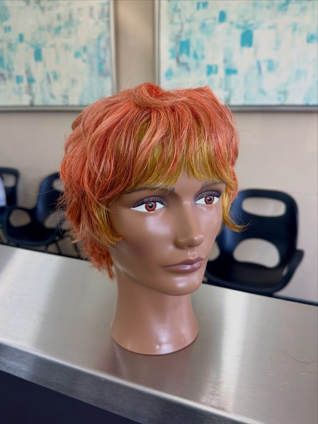 An orange pixie cut on a mannequin head